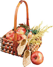 Композиция из яблок, злаков, трав и лапоточков в корзинке