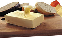 Хлеб и сливочное масло на деревянной доске. Фото