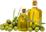 Зелёные оливки и оливковое масло в бутылках с пробкой. Фото